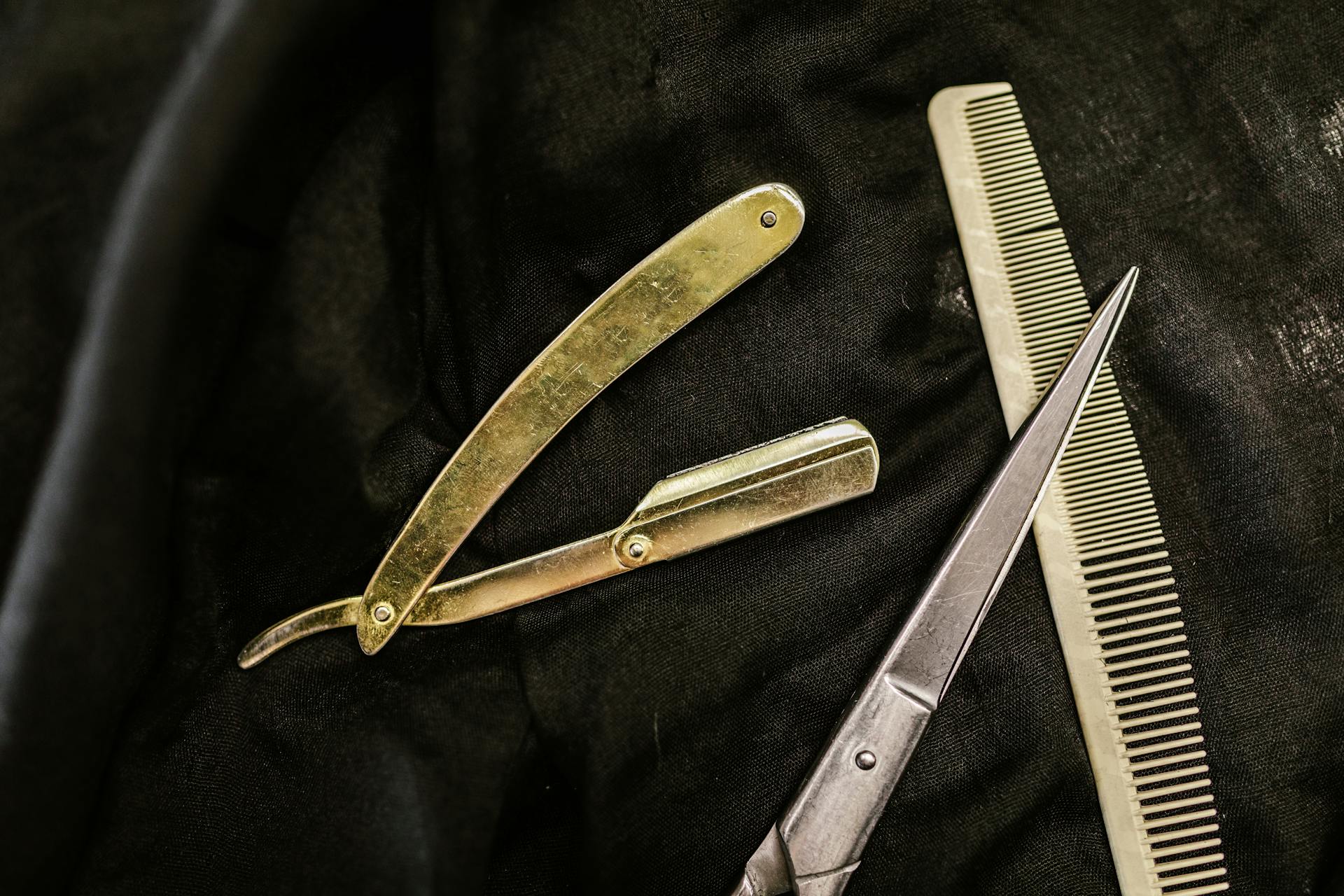 Barber tools laid out on black cloth