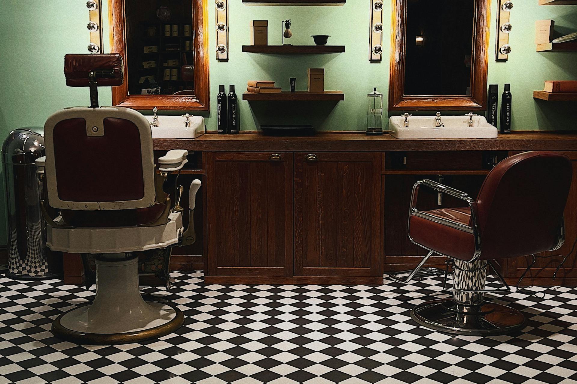 Vintage leather barber chair, art-deco lighting, dark wood panels