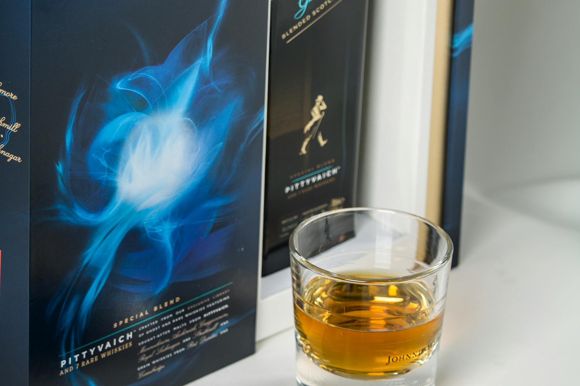 Whiskey glass and leather on bookshelf